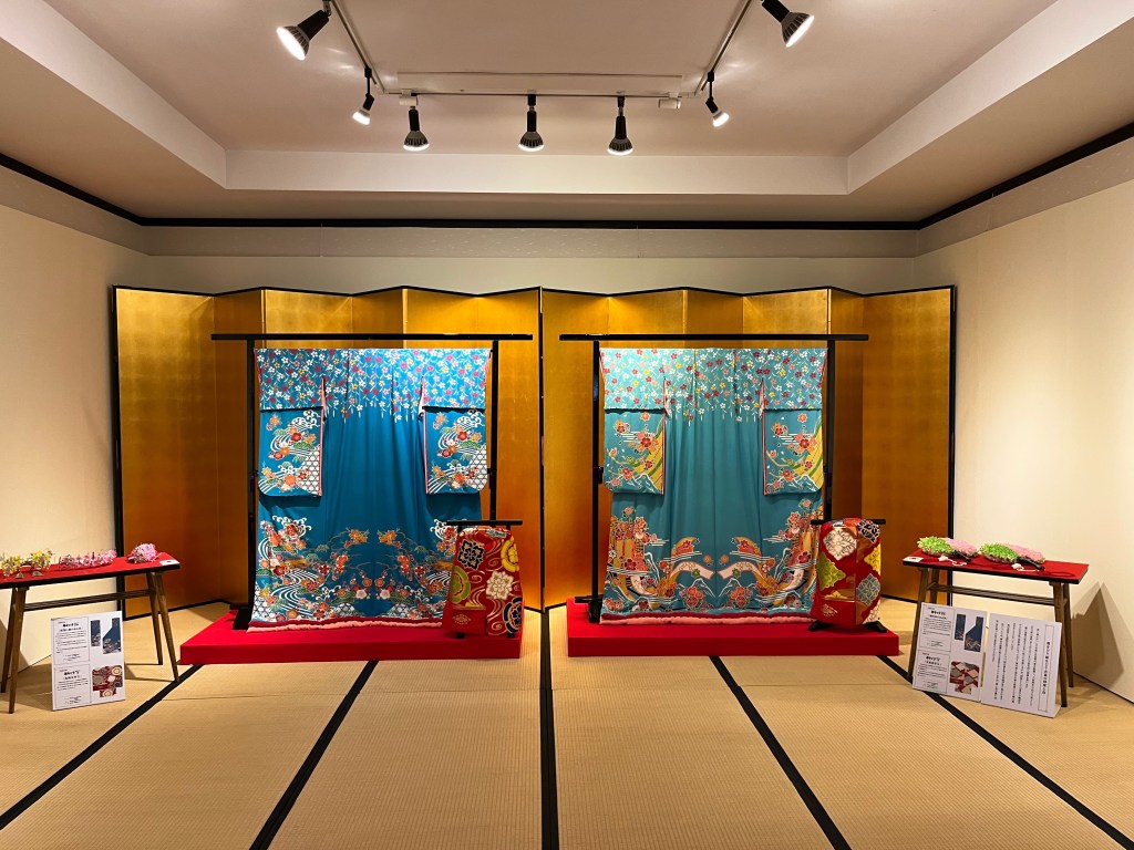 祇園花街藝術資料館展示的舞妓振袖與季節簪花，搭配金屏風與榻榻米空間重現藝妓化妝間的傳統場景。