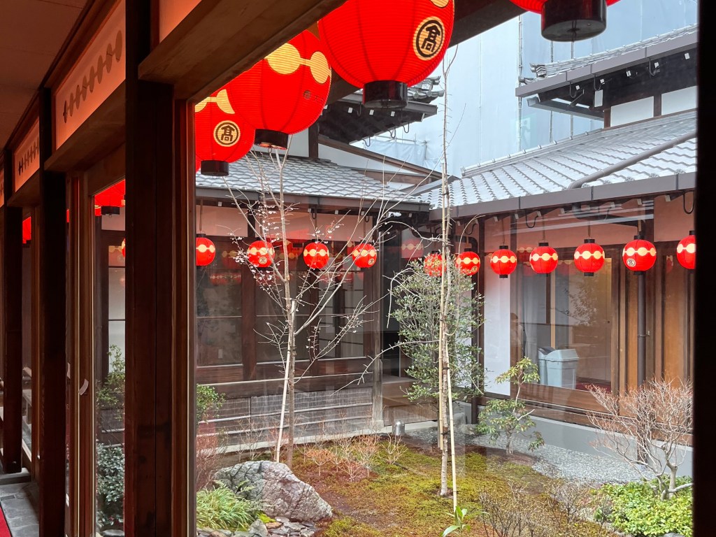 京都祇園花街藝術資料館庭園一隅，綠意盎然的池泉與碎石小徑，展現傳統日式庭園的靜謐氛圍。